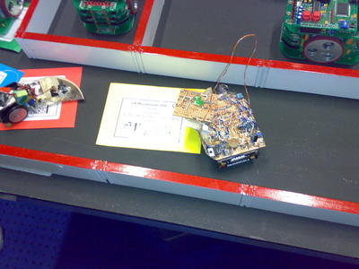 The robot in the centre is RedEye - a non-contact wall follower inherited and maintained by Chloe Hall. The robot mid left is Snoopy - a robot built by Chloe with a design slightly pilfered from her older sister, and exhibiting a gearbox problem. The three identical looking robots above were kit robots brought by the Singapore teams. The controllers and coding were different, but the chassis were all identical.